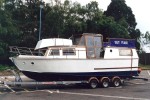 A home made boat full of character being towed from Cobbs Quay Marina to London - click to enlarge